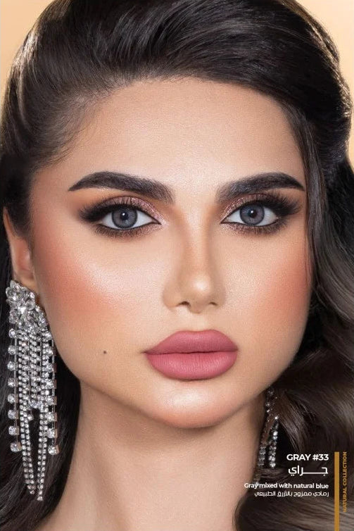 Close-up of a model with makeup and jewelry on a beige background